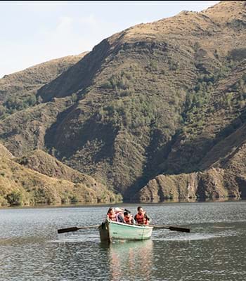 Besuchen Sie den Nationalpark Huascarán mit all seinen Attraktionen. Kredit: Shutterstock. Bootsfahrt auf einem See nahe den Gipfeln der Cordillera Blanca.