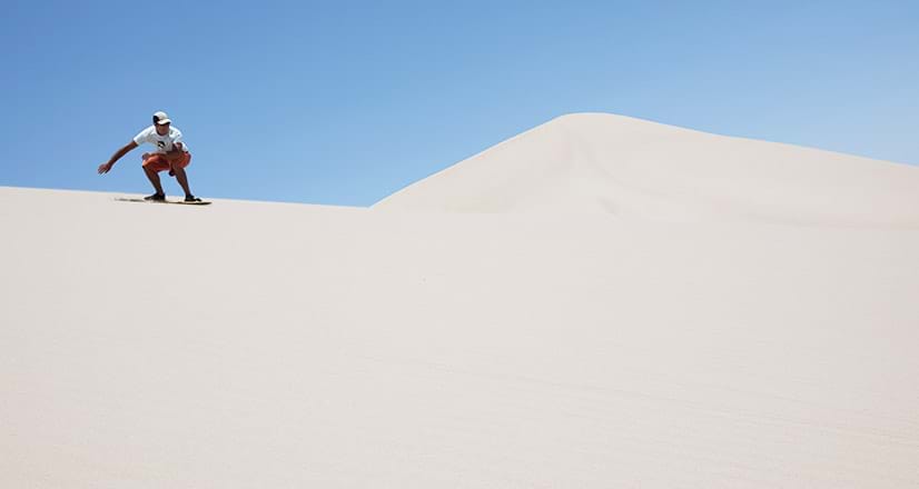 Sandboarding en las dunas cerca a la laguna Huacachina.