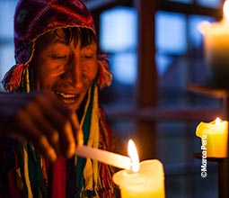 Villager lighting a candle in the Andean Lodges.