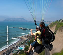 Turista haciendo parapente en la Costa Verde