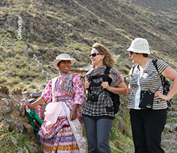 Mujer de la localidad junto a turistas en Coporaque.