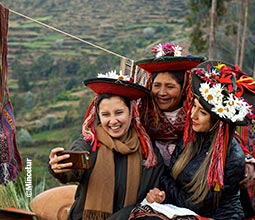 Turistas y pobladoras tomándose un selfie.