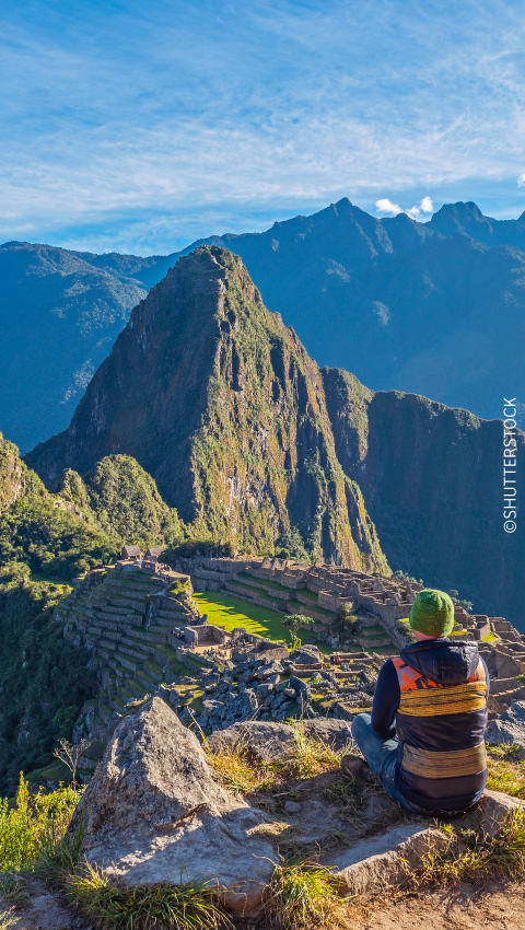 Turista apreciando Machupicchu al amanecer.