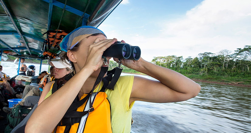 Touriste avec des jumelles dans la Réserve Nationale de Tambopata