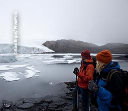 アンカシュの山の近くの湖を観察する観光客