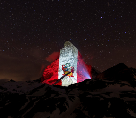 Die peruanische Flagge erleuchtet in den Schweizer Alpen