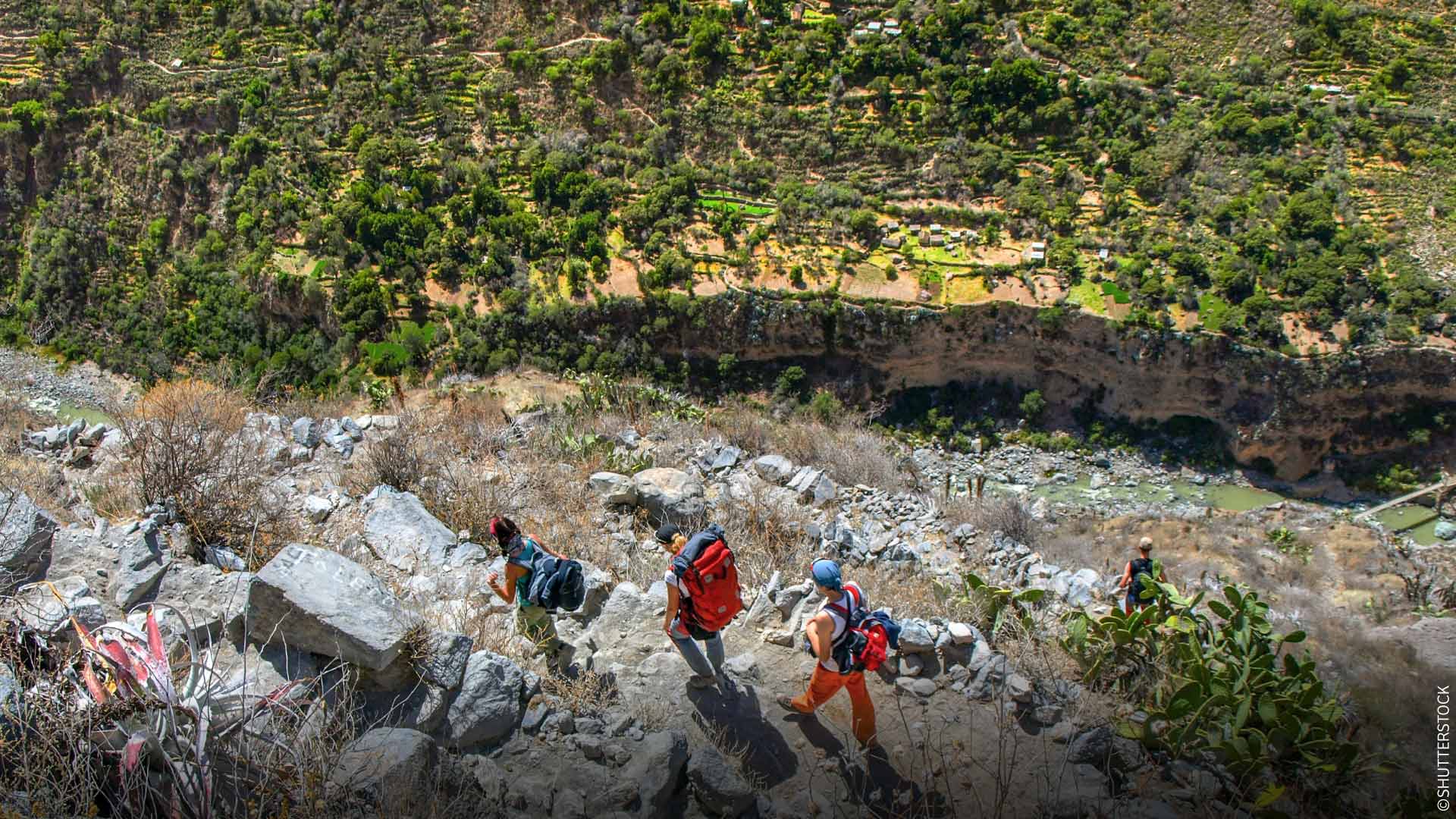 ペルーのコルカ渓谷の険しい地形を、観光客の一団が登っていく。