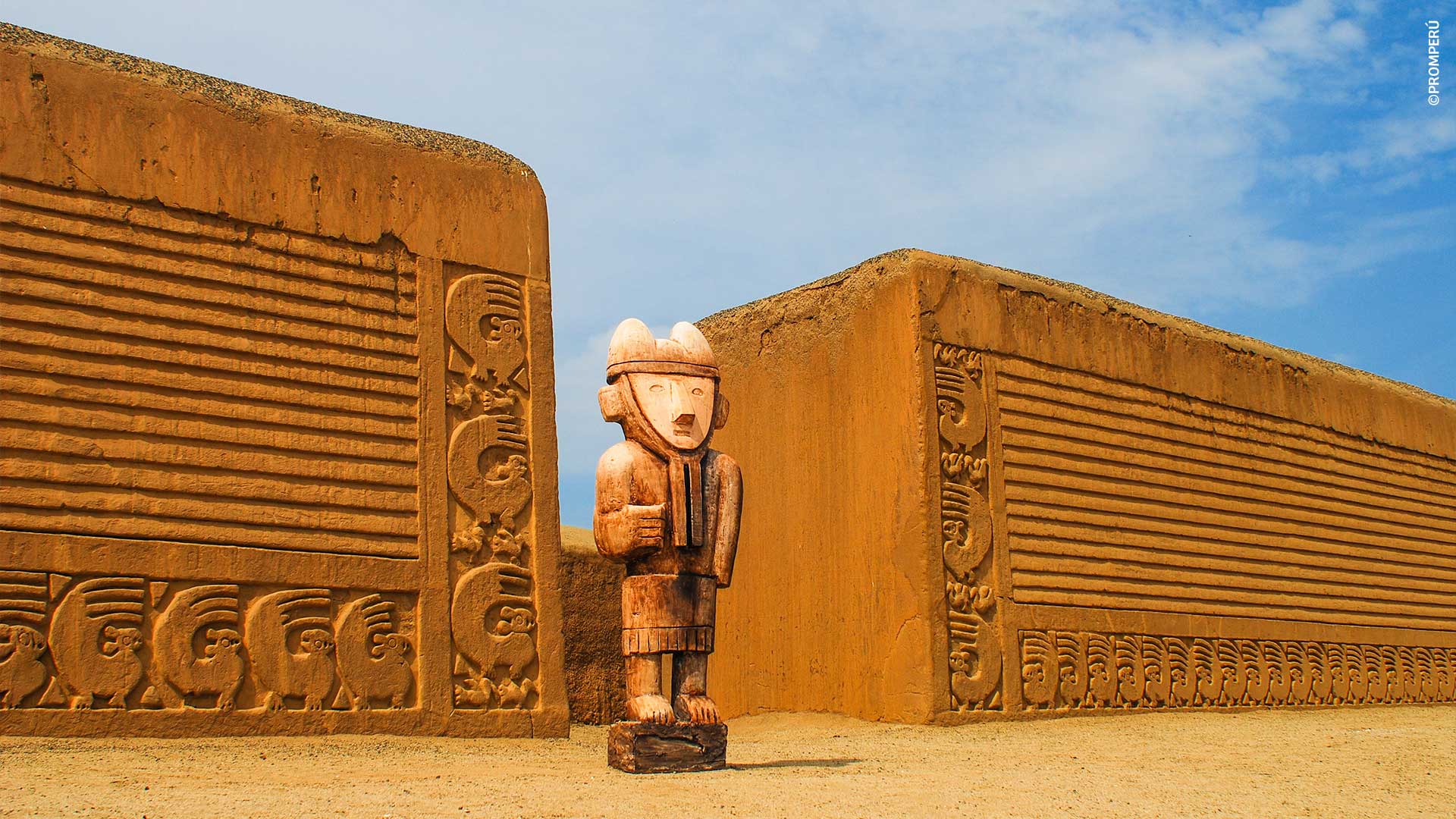 Ídolo de madera frente a muro de barro en la ciudadela de Chan Chan
