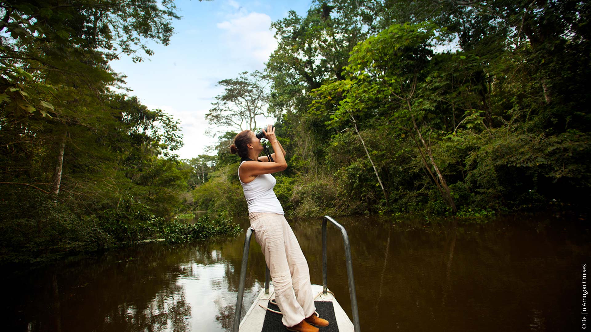 Turista observando aves en el Amazonas