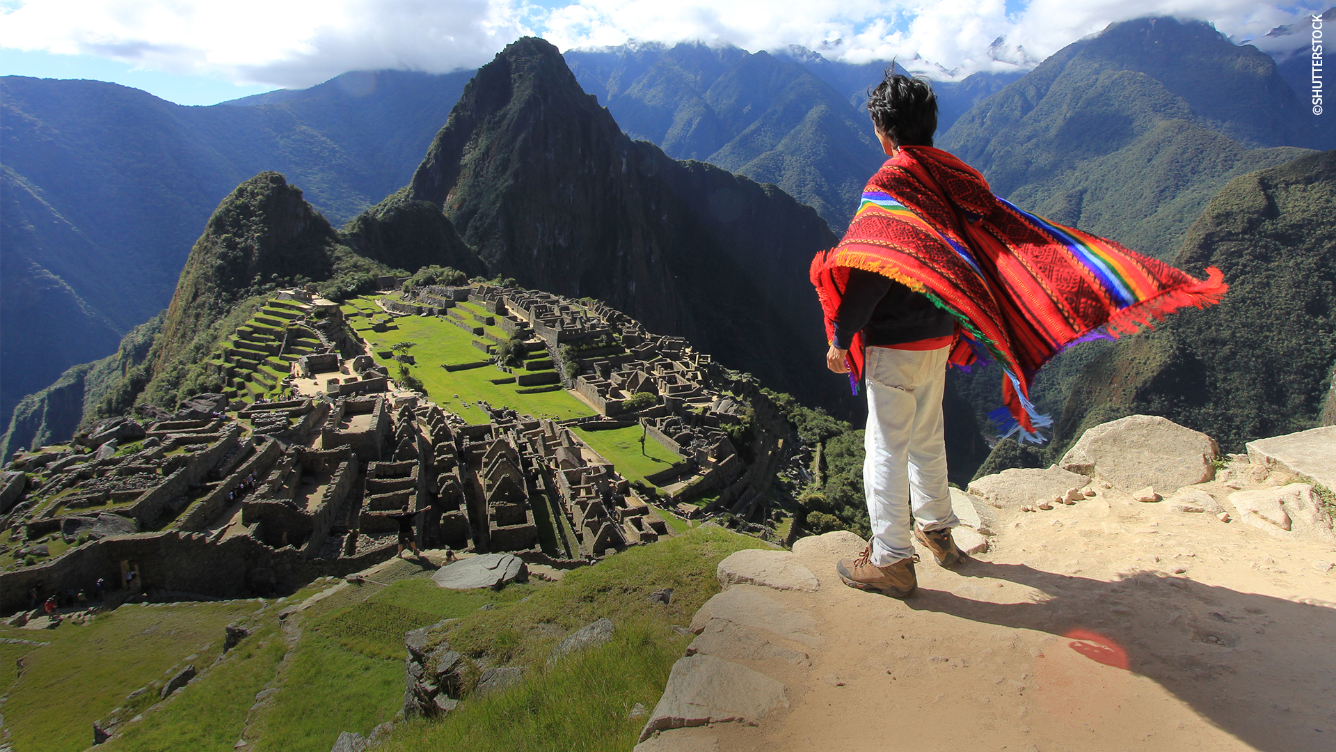 Turista con poncho peruano en Machupicchu